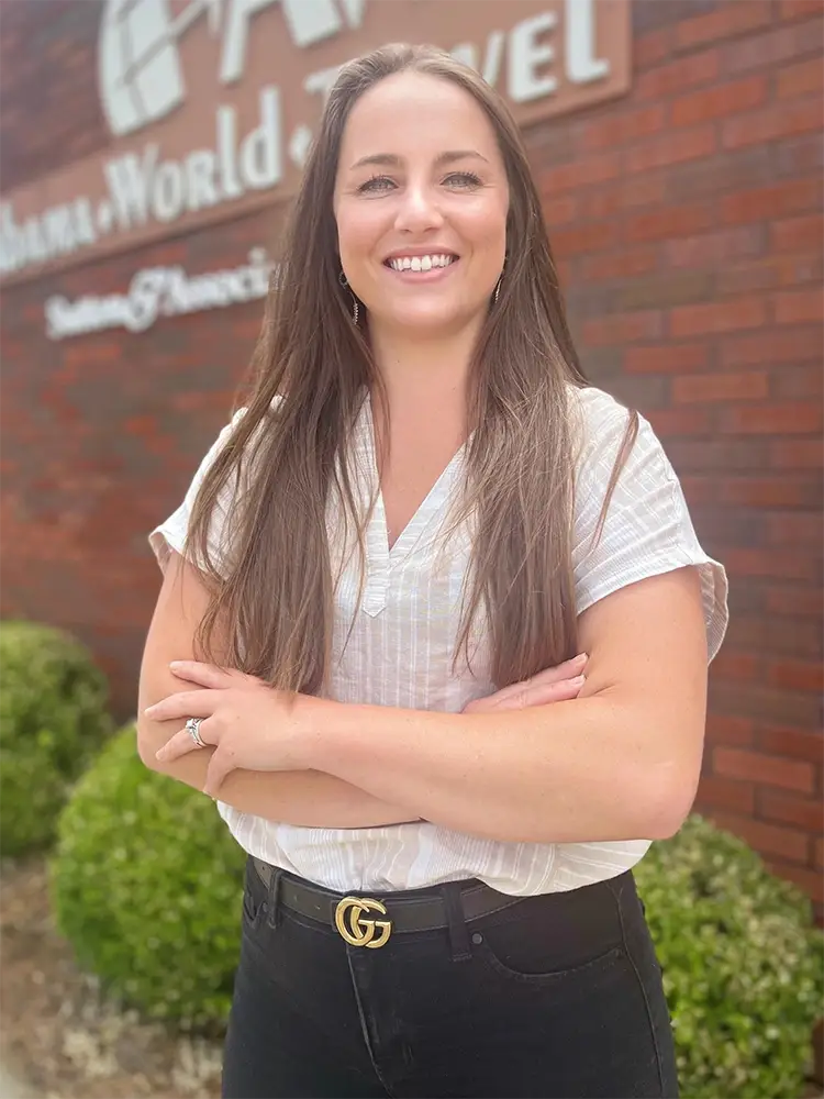 a woman standing in front of a brick building.