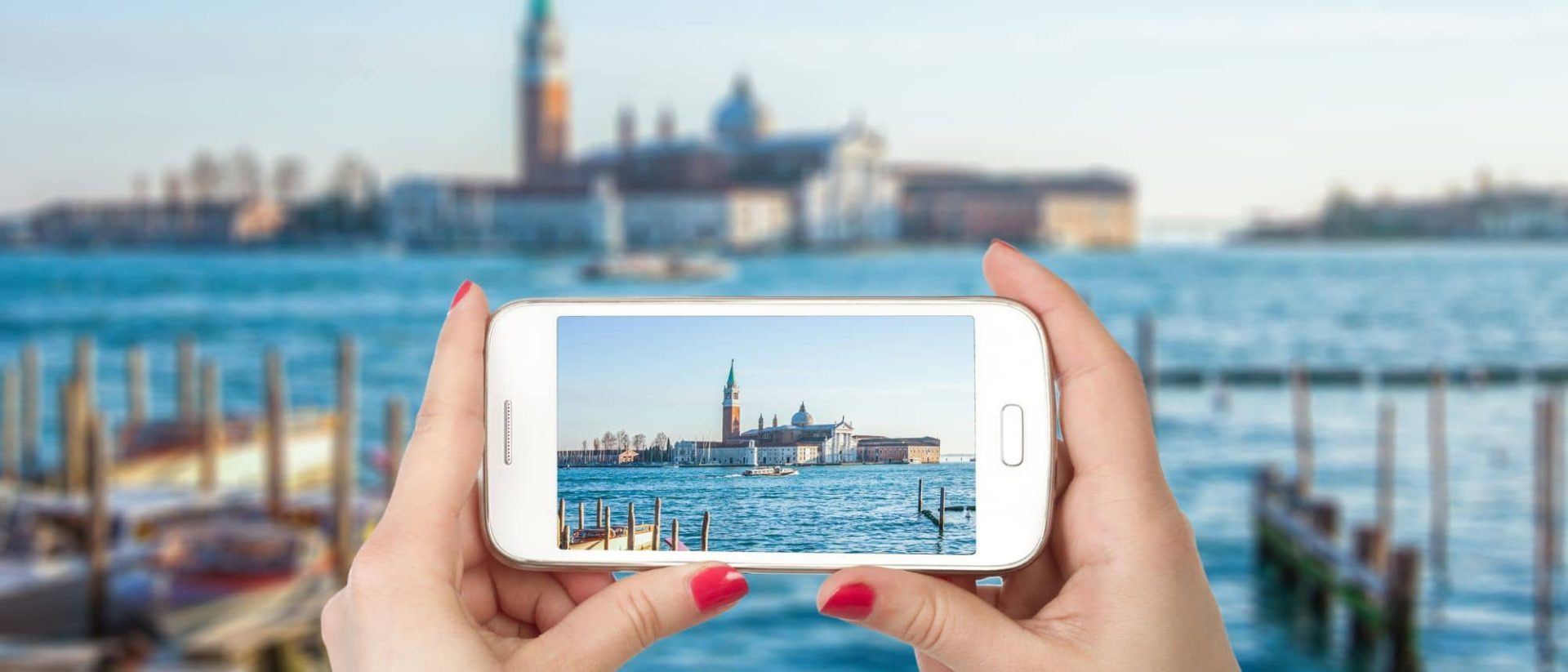 A woman is showcasing a Venice travel picture on her mobile, highlighting travel apps.