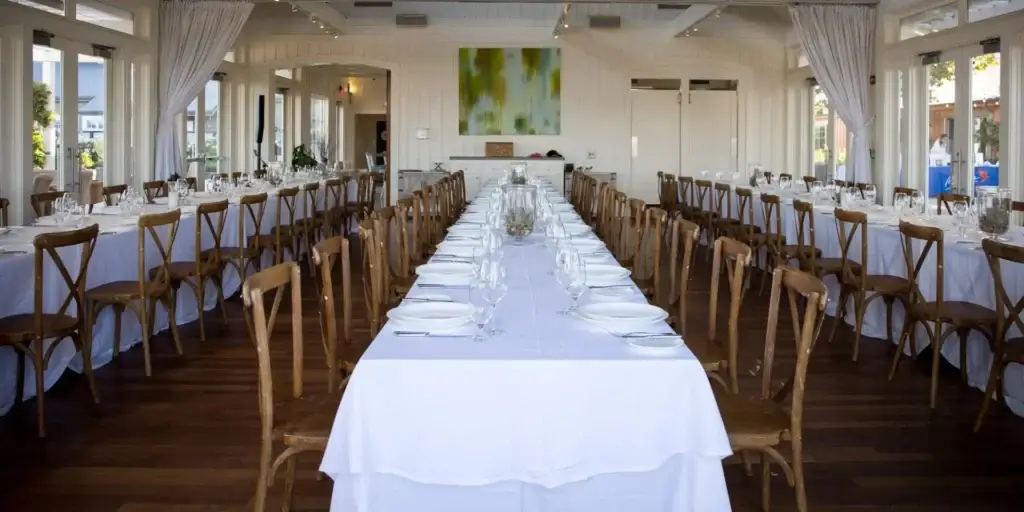 A long table is set up in a dining room for a travel incentive event.