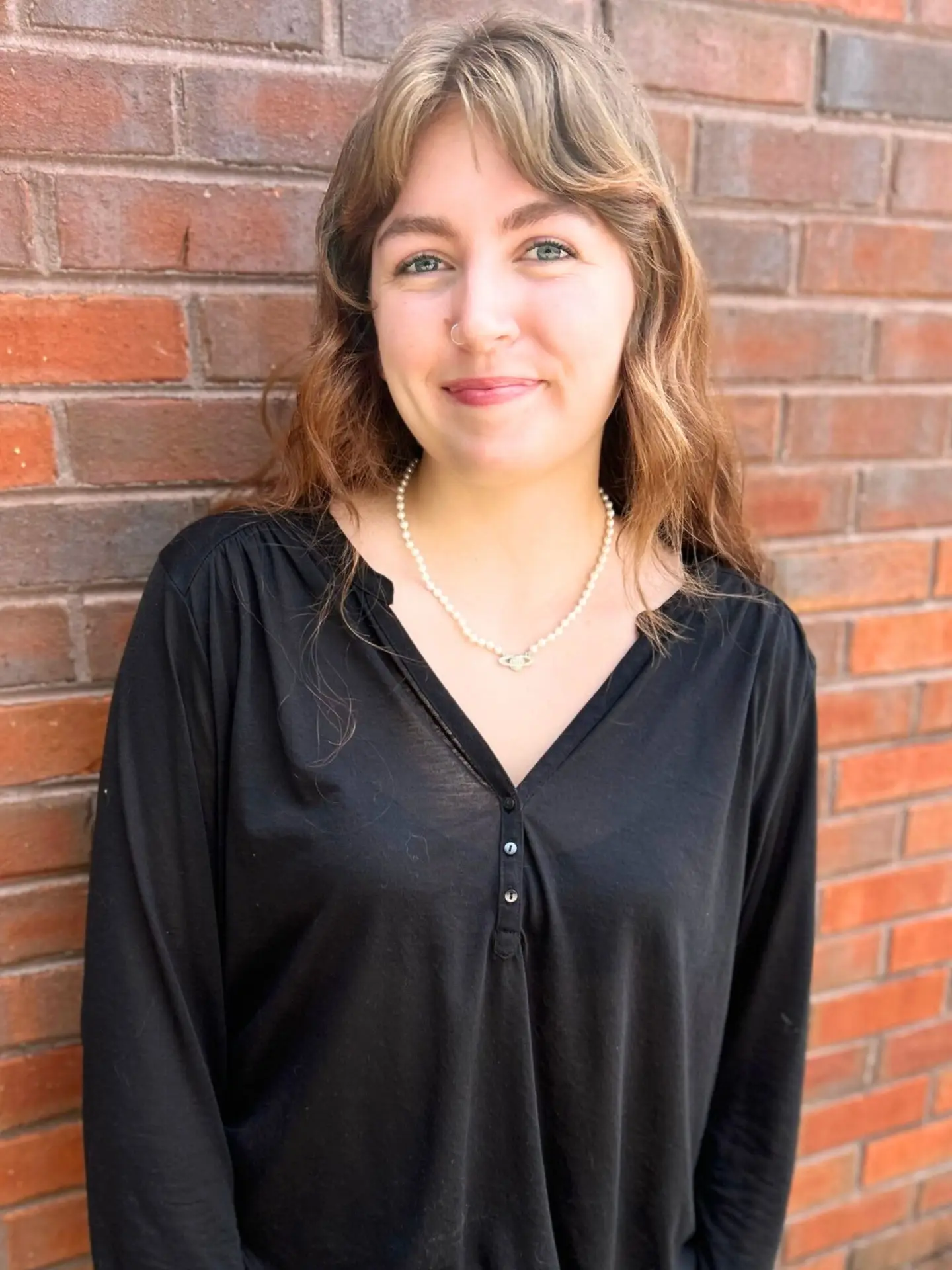 a woman leaning against a wall with her hands on her hips.